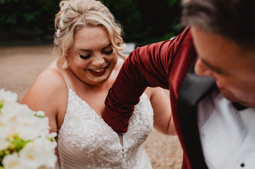 A groom reaches inside his brides bra to retrieve some confetti