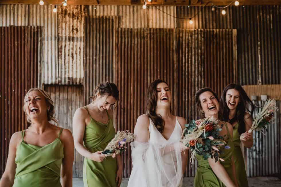 Bridesmaids laugh and walk through a wedding venue